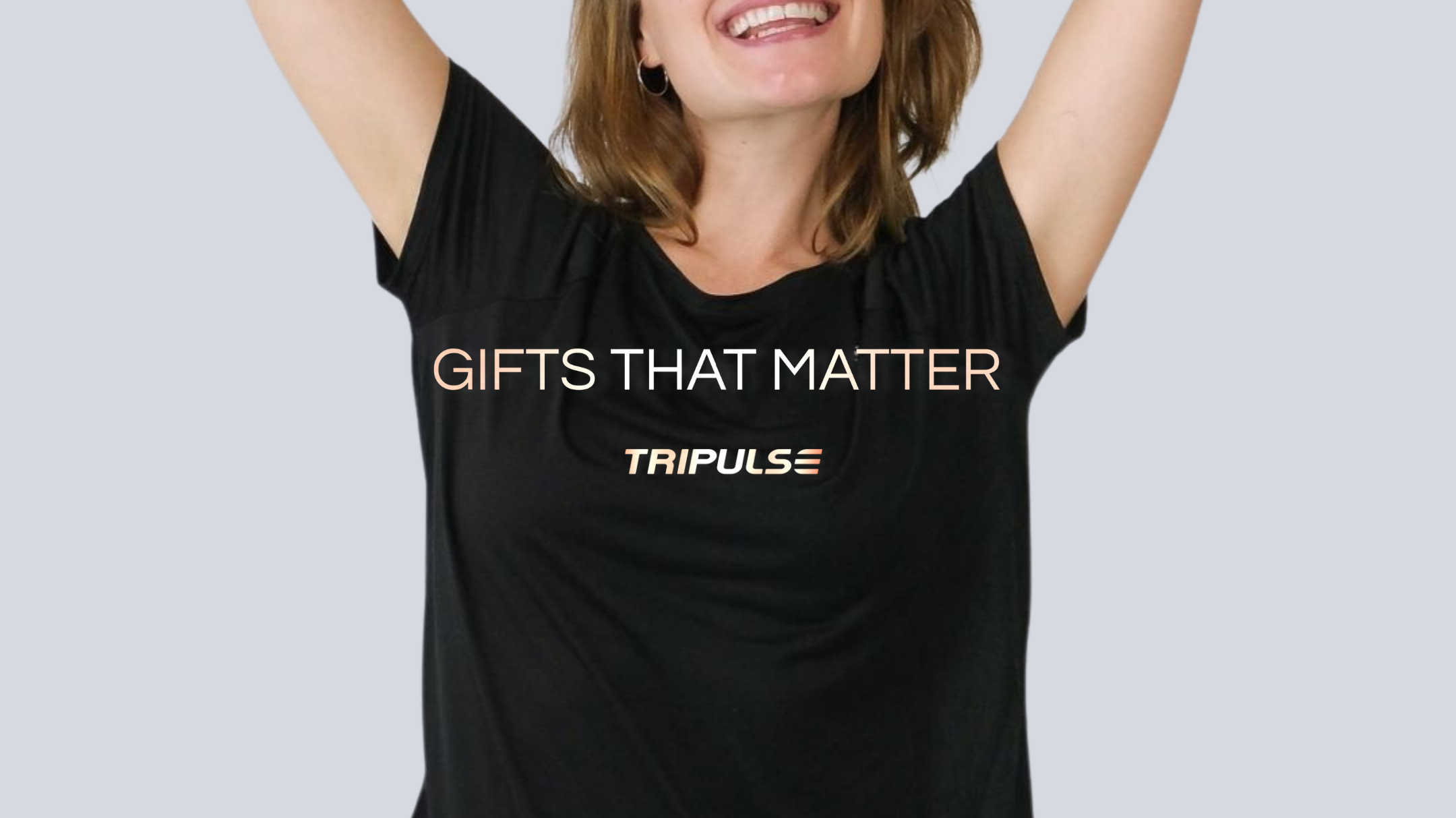 Laughing woman in a black Tripulse T-shirt printed with Gifts That Matter.