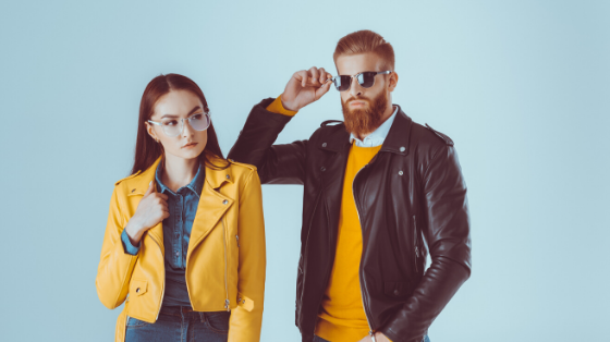 Two people posing in colorful jackets and sunglasses, fast-fashion style shot.