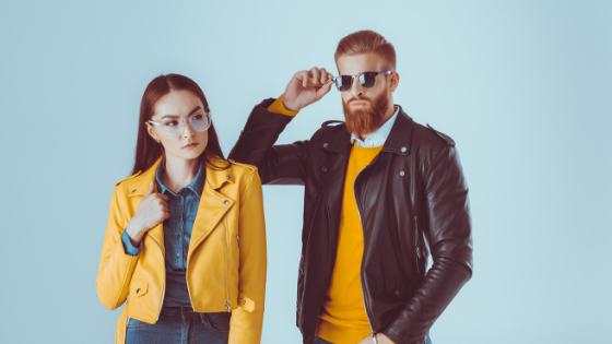 Two people posing in colorful jackets and sunglasses, fast-fashion style shot.